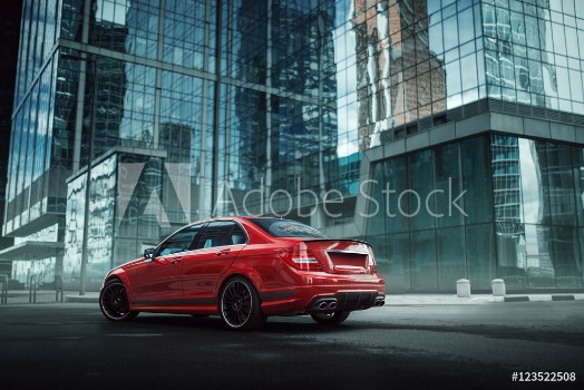 Picture of Red car stay on asphalt road in the city at daytime